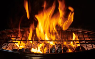 Grill Background. Barbecue Fire Grill close-up, isolated on Black Background